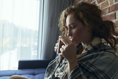 Young woman drinking coffee at home