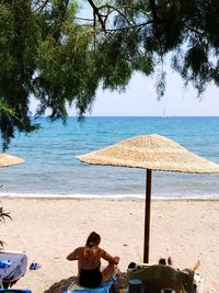 People sitting on beach by sea