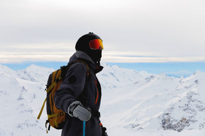 Rear view of man skiing on snow covered landscape