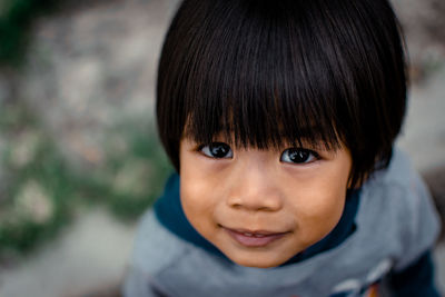 Portrait of cute boy with bangs standing outdoors