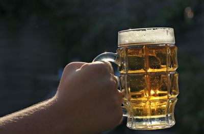 Close-up of hand holding beer glass