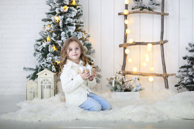 Portrait of woman with christmas tree in winter