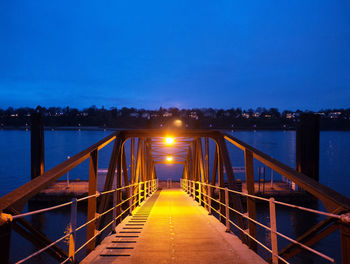 Bridge over river against clear blue sky