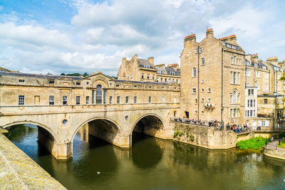 Arch bridge over river against buildings