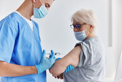 Rear view of doctor examining patient at clinic