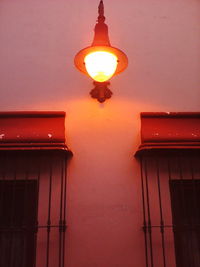 Low angle view of illuminated house against sky during sunset