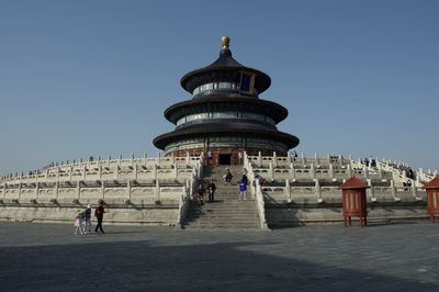 Group of people in front of building against clear sky