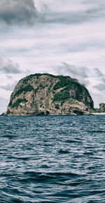 Rock formation in sea against sky