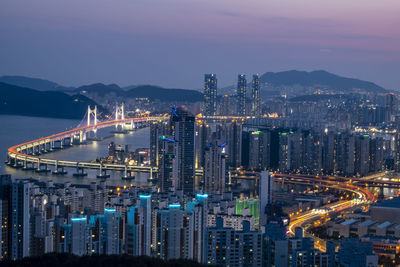 High angle view of illuminated city against sky at dusk