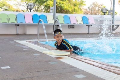 Portrait of boy sitting in swimming pool