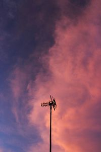 Low angle view of silhouette telephone pole against sky during sunset