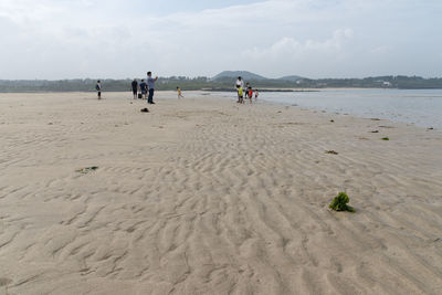 People at beach against sky