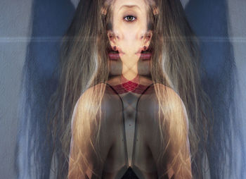 Double exposure of young woman by wall