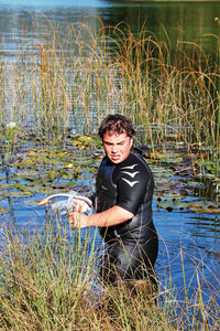 Young man standing in lake