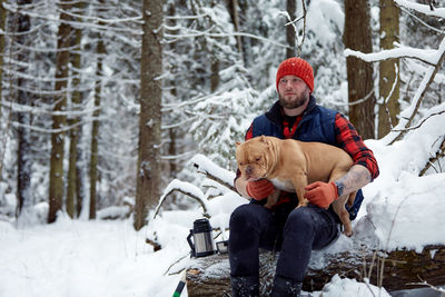 Portrait of man sitting on snow covered landscape