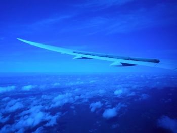 Airplane wing against blue sky