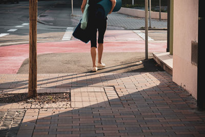 Low section of woman walking on footpath