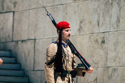 Full length of young man standing against wall