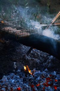 Sausages roasting in metal grate over barbeque