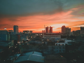 Modern buildings in city against sky during sunset