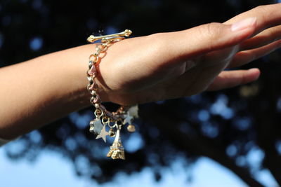 Close-up of woman hand holding cross against blurred background