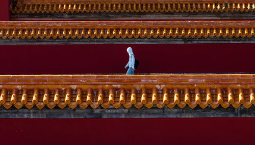 Side view of man walking against built structure