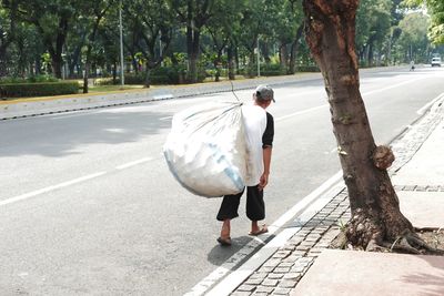 Rear view of man walking on road