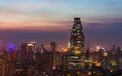 Illuminated buildings in city against sky at night