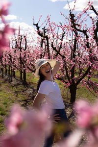 Portrait of happy woman surrounded by peach trees in bloom in aitona, catalonia, spain