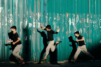 Boys running against corrugated wall