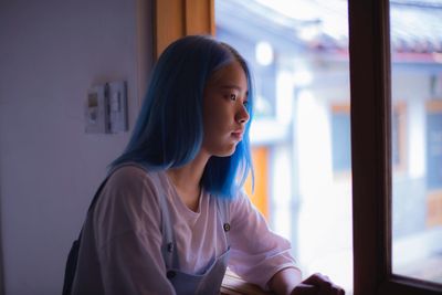 Beautiful woman looking through window