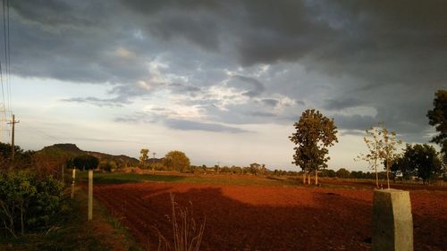 Scenic view of field against cloudy sky