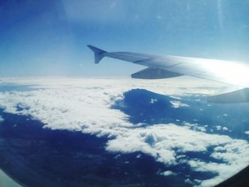 Cropped image of airplane flying over cloudscape