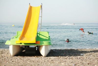 People on beach by sea against sky