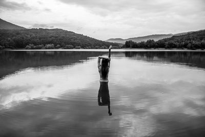 Reflection of person in lake against sky