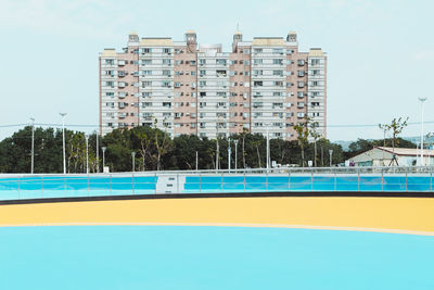 Swimming pool by building against sky