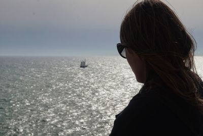 Rear view of woman looking at sea against sky