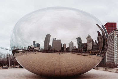 Digital composite image of buildings against cloudy sky