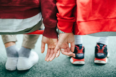 Low section of couple sitting on railing