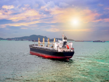 Ship moored at harbor against sky during sunset