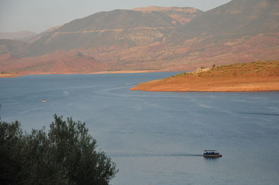 Scenic view of sea and mountains against sky