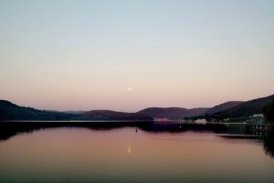 Scenic view of lake against clear sky during sunset