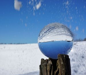 Close-up of blue sea against sky during winter