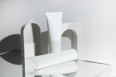 Close-up of white objects on table against wall