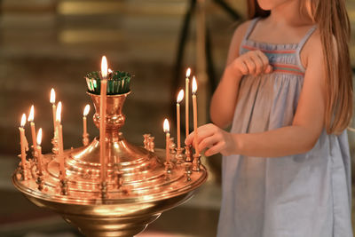 A little girl puts a candle in church. orthodoxy