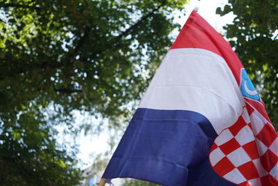 Low angle view of flag against trees