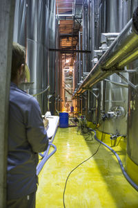 Worker controlling stainless steel tanks for food industry