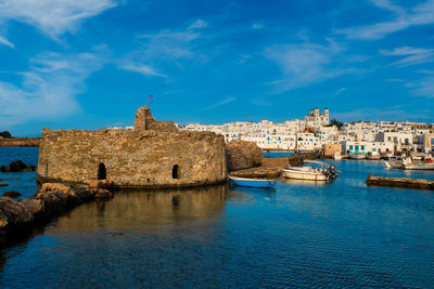 View of canal and buildings against blue sky