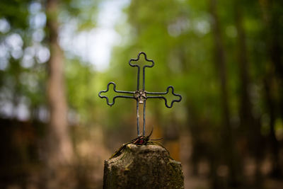 Close-up of metallic cross on concrete