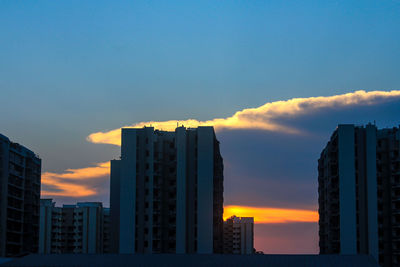 Modern buildings against sky during sunset